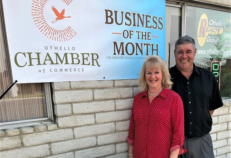 Brenda and Drew Roosma, co-founders of the Othello Realty Group, stand outside their office in front of an Othello Chamber of Commerce business of the month banner from June 2019. Brenda said the Othello housing market is strong compared to surrounding areas.