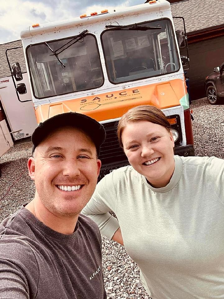 Matt Arnold-Ladensack, co-owner of Clydesdale Outpost, and employee Jordan Glosser photographed in front of a food truck the pair were planning to launch in Whitefish. The two were injured when the truck burst into flames earlier this month. (Courtesy photo)