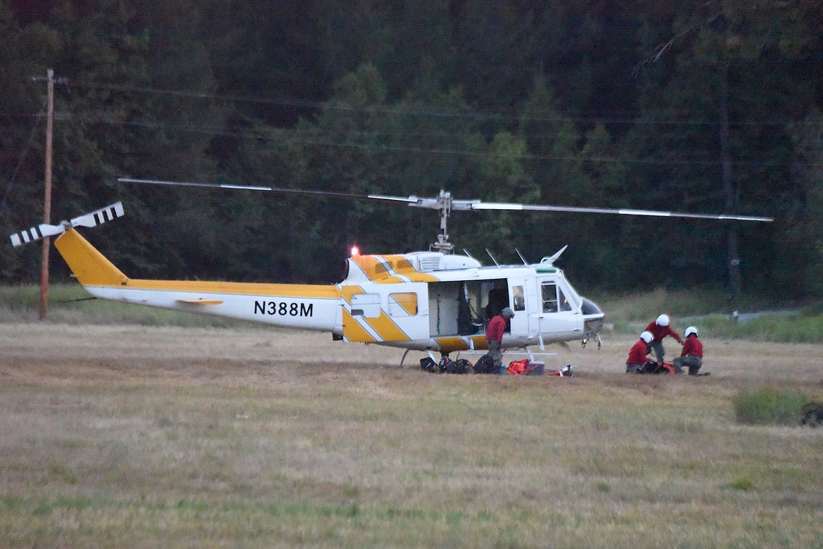 Firefighters prepare to board a helicopter fighting the Gravel Pit Fire on Friday, Aug. 4. (Scott Shindledecker/The Western News)