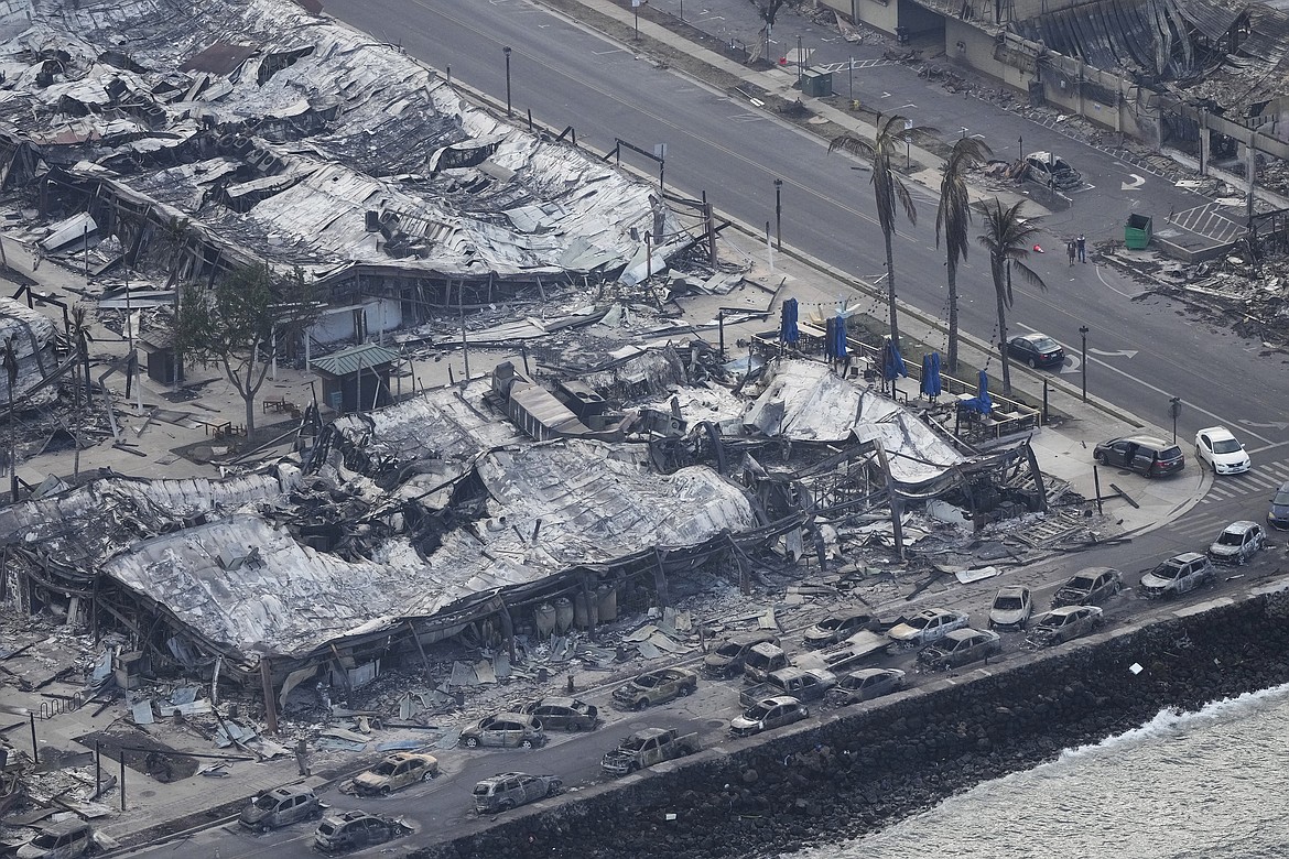 A banyan tree rises among the Wildfire wreckage, Thursday, Aug. 10, 2023, in Lahaina, Hawaii. For 150 years, the colossal tree shaded community events, including art fairs. It shaded townsfolk and tourists alike from the Hawaiian sun, befitting for a place once called “Lele,” the Hawaiian word for “relentless sun.” Like the town itself, its very survival is now in question, its limbs scorched by a devastating fire that has wiped away generations of history. (AP Photo/Rick Bowmer)