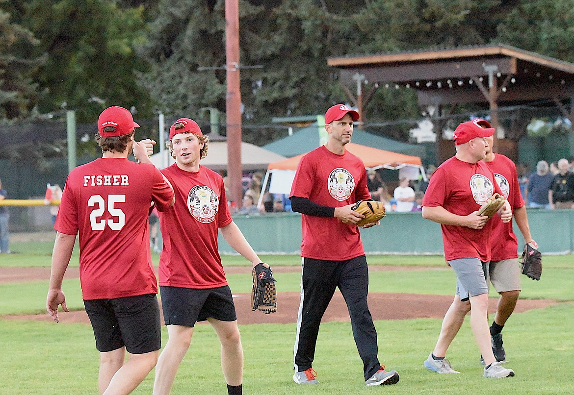 Hoses team members congratulated each other after closing the sixth inning at the 2023 Guns and Hoses game at Lee Gehring Field in Libby on Thursday, Aug. 10. (Scott Shindledecker/The Western News)