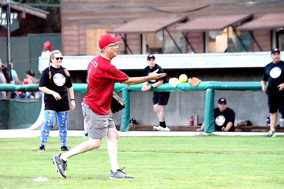 Libby Volunteer Fire Department Chief Steve Lauer delivers a pitch during the Sixth Annual Guns and Hoses game at Lee Gehring Field on Thursday, Aug. 10. (Scott Shindledecker/The Western News)