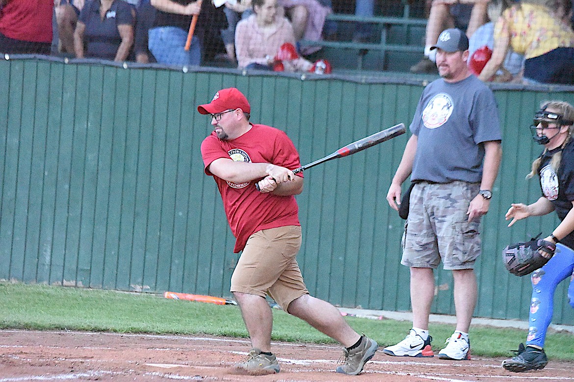 Hoses team member Steve Scheer swings away at the 2023 Guns and Hoses game at Lee Gehring Field in Libby on Thursday, Aug. 10. (Scott Shindledecker/The Western News)