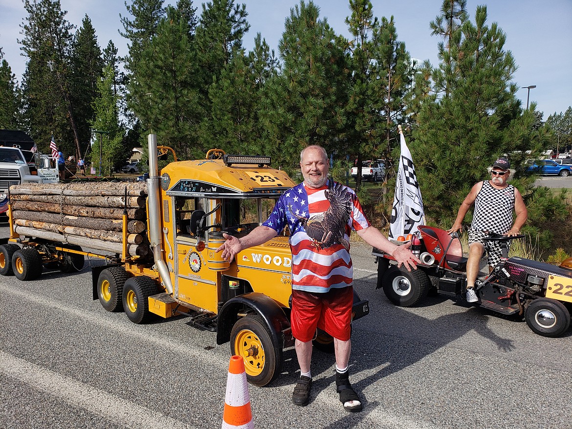 Michael Baslington prepares to drive the Pecker Pole Loggin' truck through the Athol Parade on Saturday as George Zick hops onto his rig for the races.