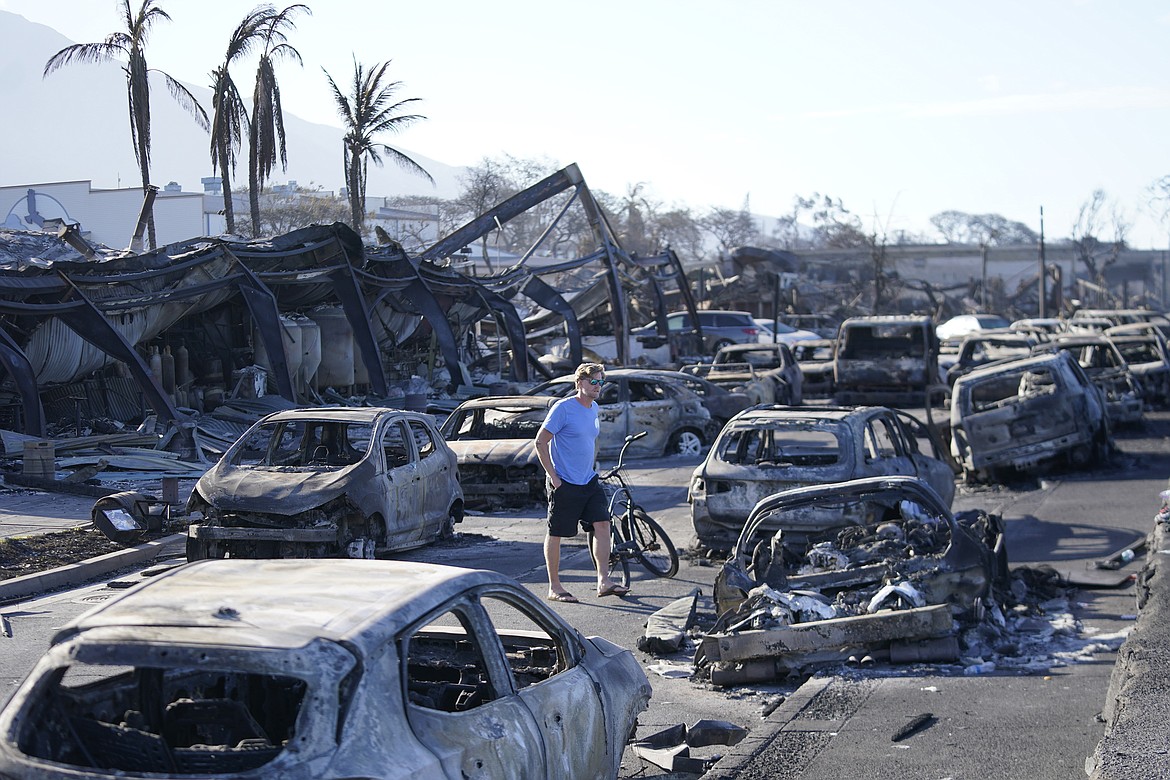 A man walks through wildfire wreckage Friday in Lahaina, Hawaii.