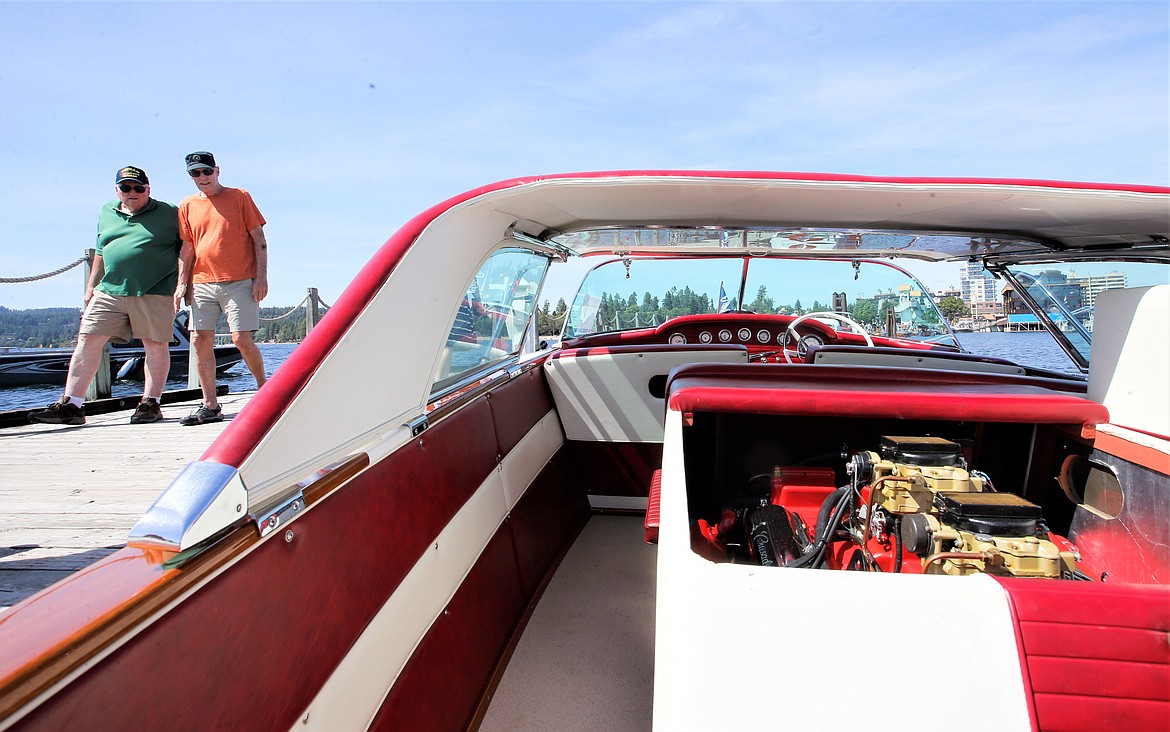 Visitors walk near Wes Yandt's 1958 Century Coronado at the Coeur d'Alene Antique and Classic Boat Festival at The Boardwalk on Saturday.