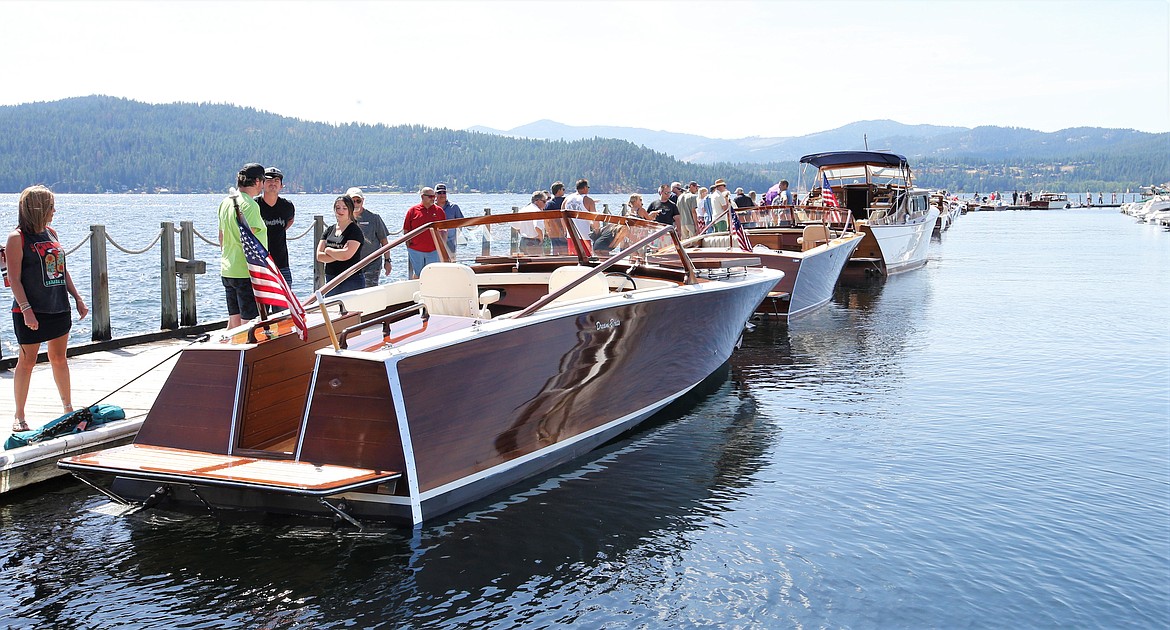 People check out boats in the Coeur d'Alene Antique and Classic Boat Festival at The Boardwalk on Saturday.