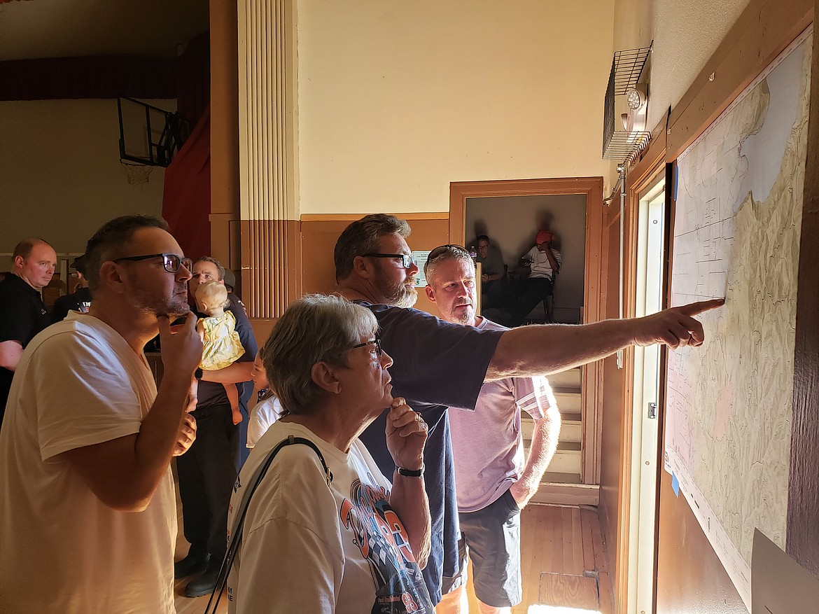 Residents pore over maps of the Ridge Creek Fire during a community meeting hosted by the incident response team and local jurisdictions to share information about the fire.