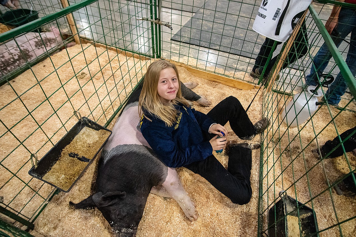 Abbie McCatchey and pig Pickles rest up before the competition at Flathead County Fairgrounds in Kalispell on Monday, Aug. 14. (Avery Howe/Hungry Horse News)