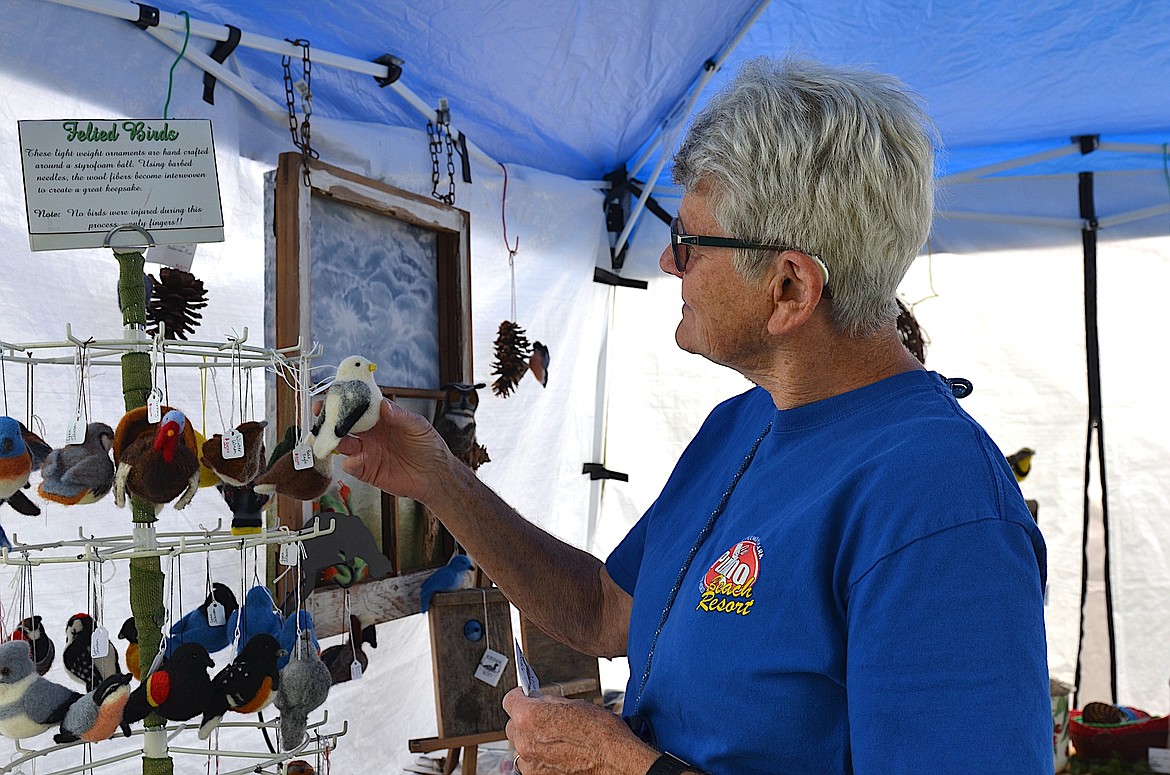 Ann Marie Dussault, a former county commission and state legislator from Missoula, checks out a felted bird at Lynn Johnson's booth during Saturday's Courthouse Art Festival. (Kristi Niemeyer/Leader)