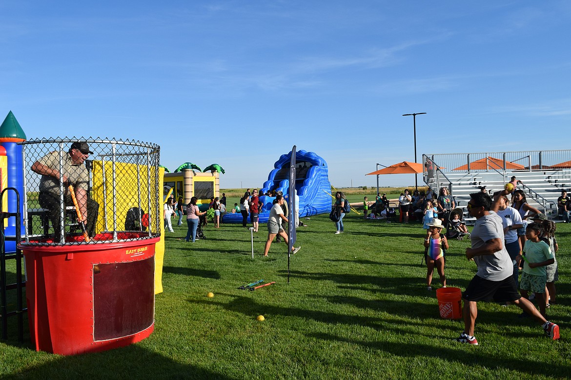 A member of the community attempts to hit the dunk tank target to drop Adams County Sheriff Dale Wagner into the water during National Night Out.