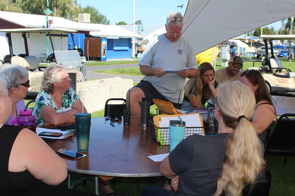 Grant County Fairgrounds Manager Jim McKiernan looks over a list of instructions for fair volunteers Monday morning. The list included instructions on keeping cool, since temperatures for the first three days are forecast to be in excess of 100 degrees.