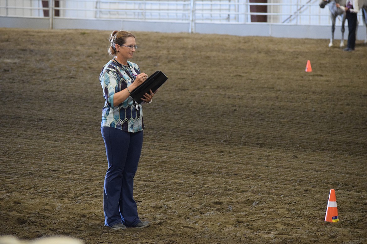 Competition judge Heidi Bach eyes the skill of a young equestrian and makes notes during Tuesday’s competition. Bach said she competed herself when she was young and began judging at 18.