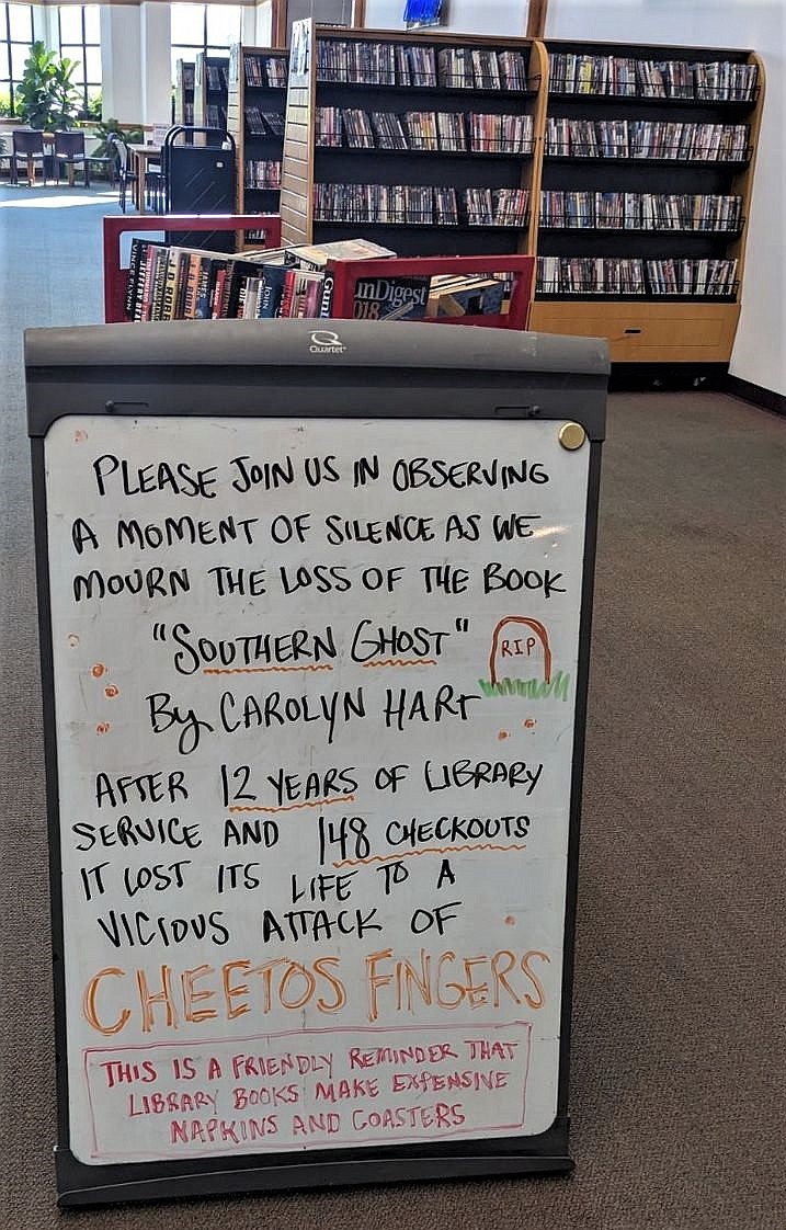 A sign at the Hayden Library addresses damage caused to children's books by "CHEETOS FINGERS." (Olivia Heisey photo)