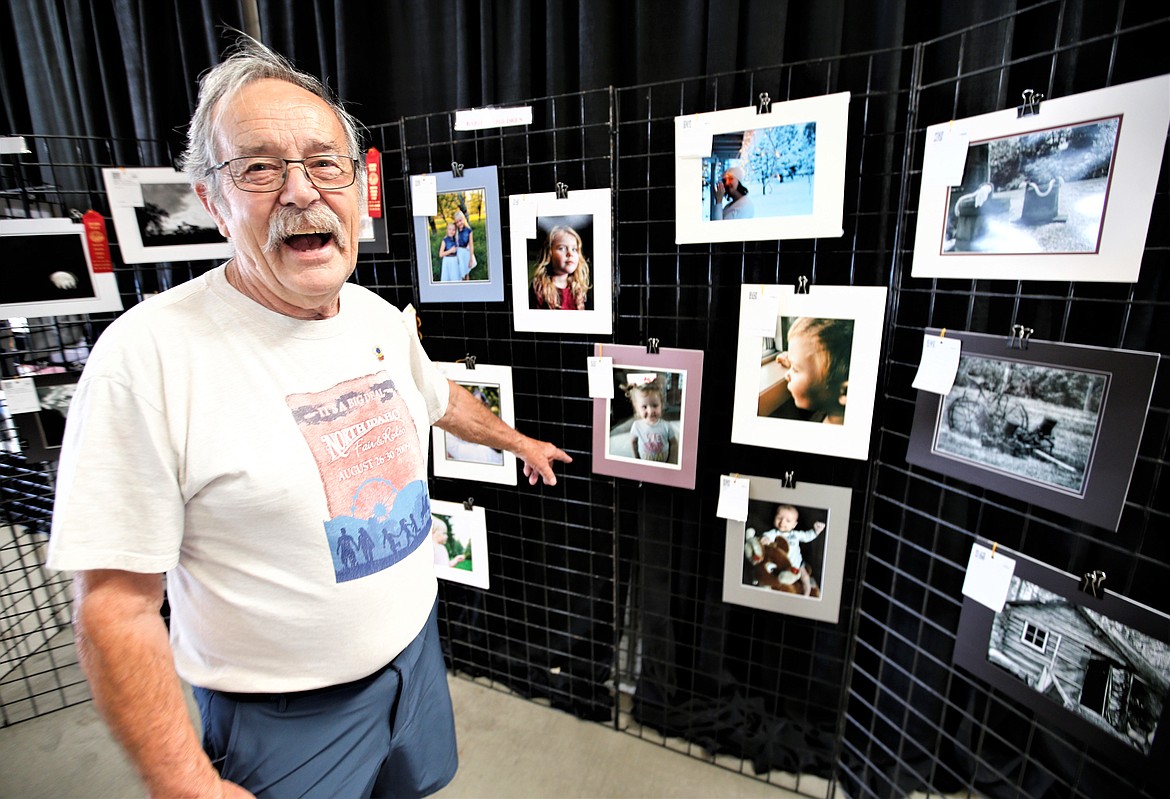 Ken Cook, superintendent of the art and photography building at the North Idaho State Fair, laughs on Wednesday as he points toward his photograph of his great-granddaughter that will be on display at the fair, which opens Friday.