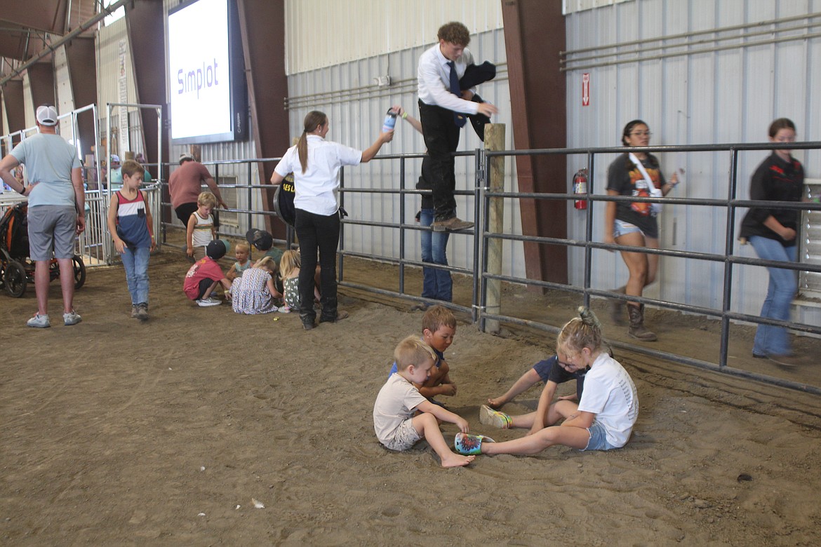 MOSES LAKE - As fair activities go on around them, children find a spot to play in the dirt in the Ardell Pavilion at the Grant County Fair Wednesday.