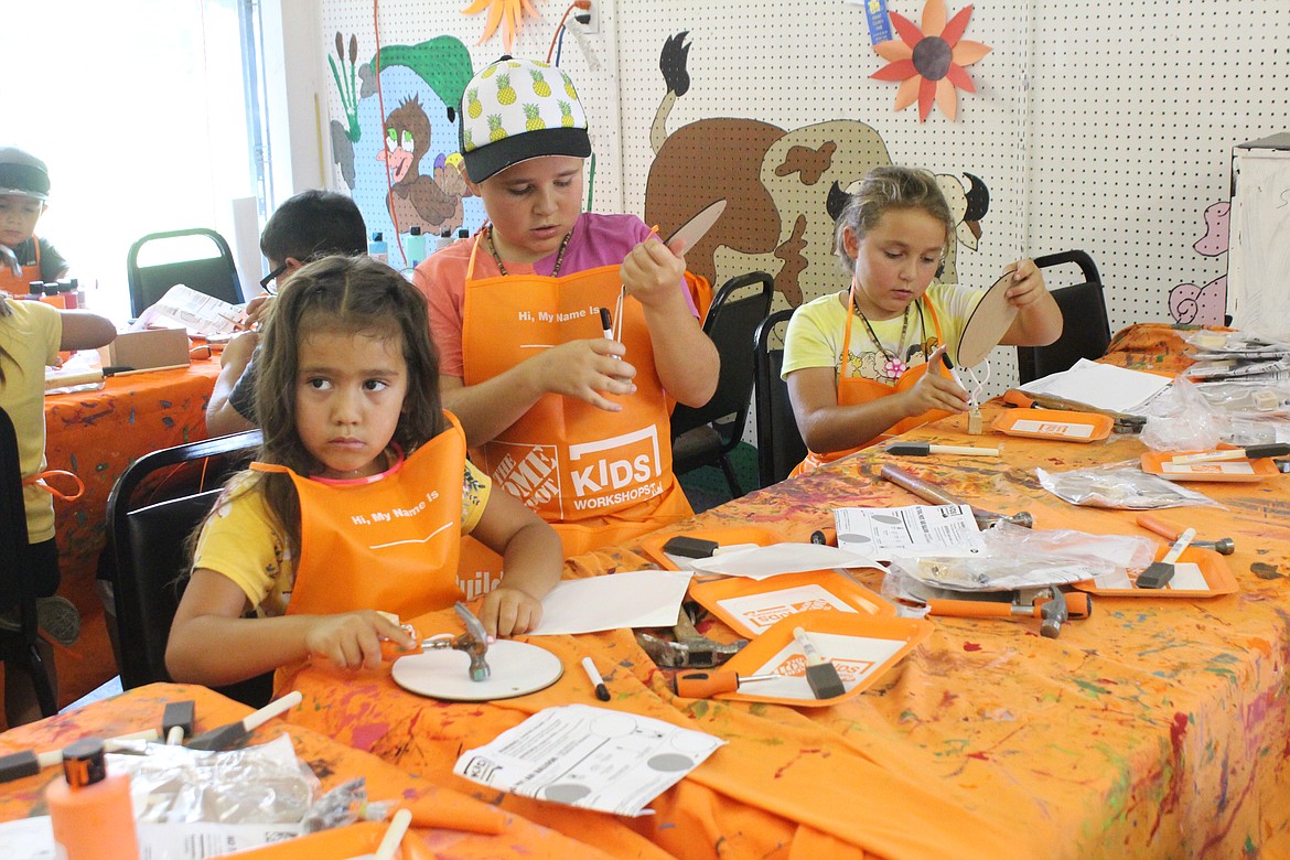 From left, Myra Toto, Olivia Hochstatter and Charlotte Hochstatter work on their message boards at the Kids Workshop, sponsored by the Home Depot, at the Grant County Fair.