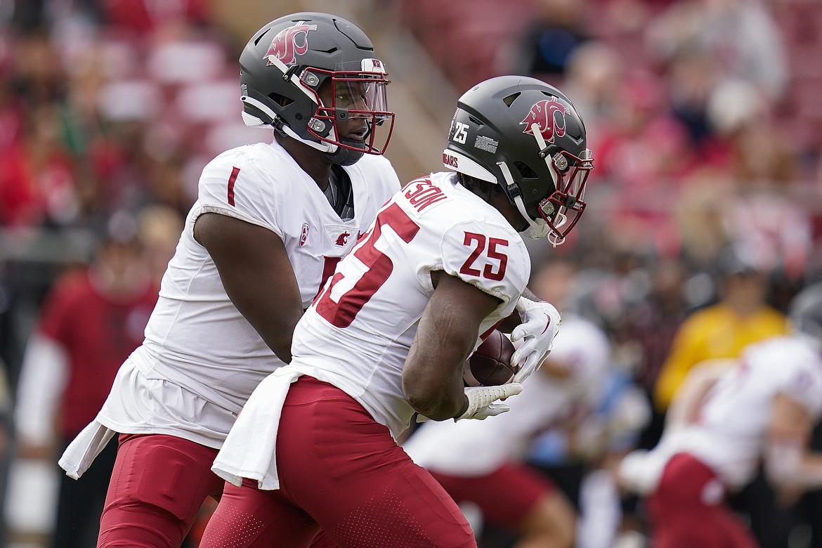 Washington State quarterback Cameron Ward (1) hands the ball off to running back Nakia Watson (25). Ward was named to the Maxwell Award preseason watch list, while Watson was named to the Doak Walker Award watch list.