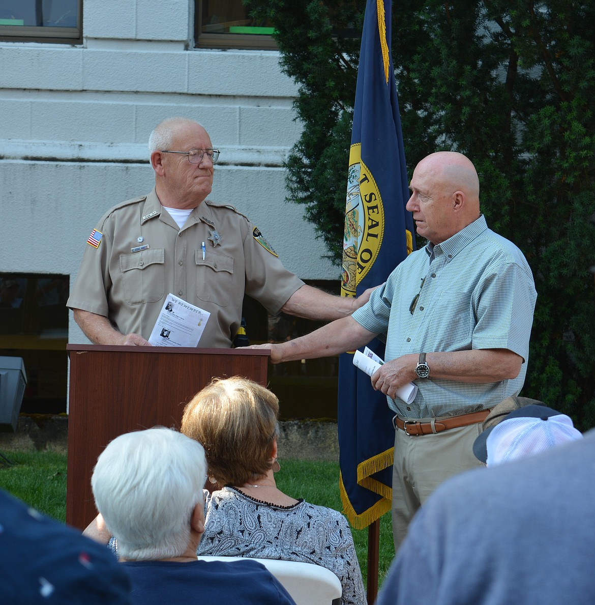 Spike Angle comforts Roy Reel during the dedication of a memorial marker for two fallen police officers who were killed of the line of duty in Shoshone County.