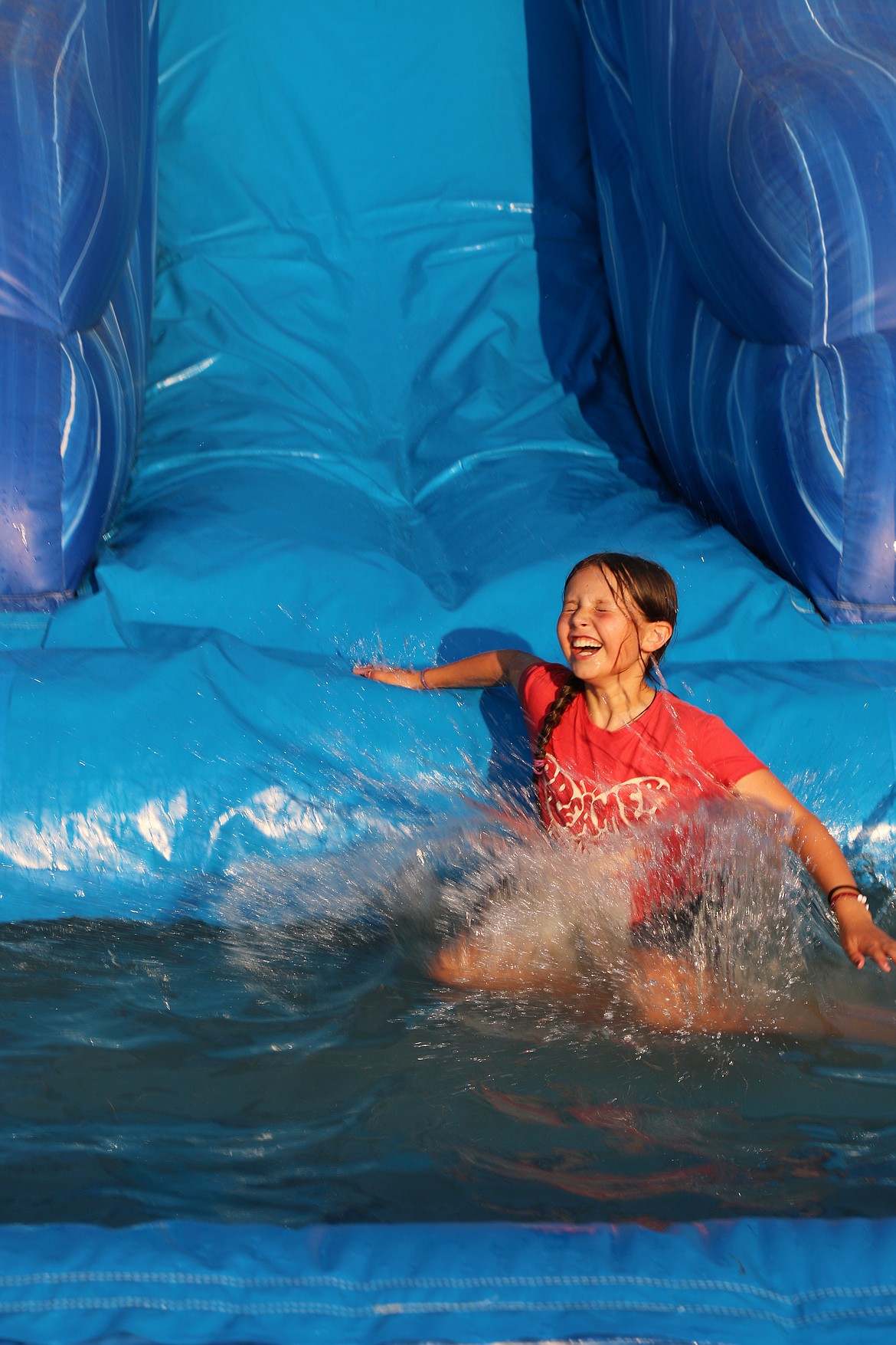 A youngster takes advantage of an inflatable water slide at the Bonner County Fair to cool off on Wednesday.