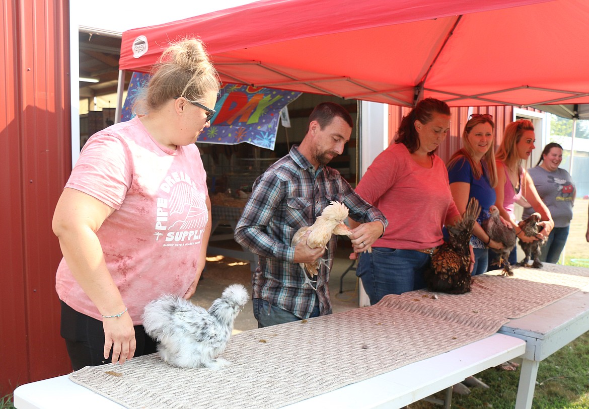 Poultry category participants demonstrate where the different parts of the fowl are located as they take part in an event at the Bonner County Fair on Thursday.