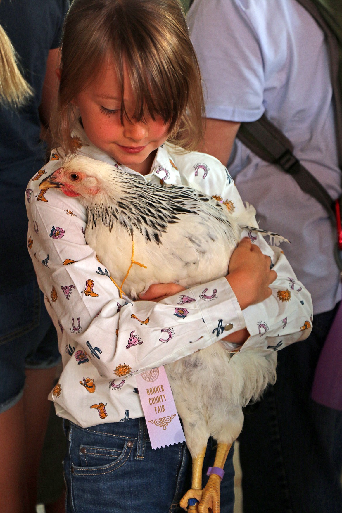 A youngster holds her chicken while taking part in the Bonner County Fair on Thursday.