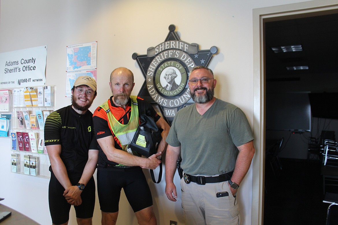 Axel Andersson, left, and his dad Eric Andersson, center, stopped at the Adams County Sheriff’s Office in Othello at the request of Adams County Sheriff Dale Wagner, who planned to give them a souvenir of their stop in Adams County. Because Wagner couldn’t be there, ACSO sergeant Ben Buriak did the honors. It was, Axel Andersson said, their second souvenir of their trip across the U.S. Axel’s hat from Stockholm, Wisconsin is the other one.