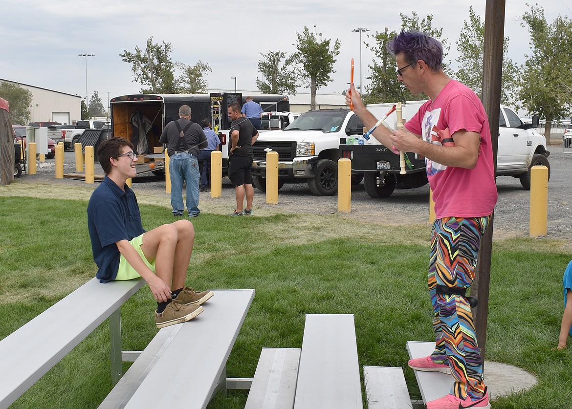 A professional Zaniac Alex Zerbe bounces a paddleball at a young audience member while encouraging him to catch the ball in his teeth. The boy, probably wisely, declined.