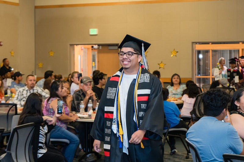 A TRiO Upward Bound graduate beams as he walks during the program's graduation ceremony at Big Bend Community College.