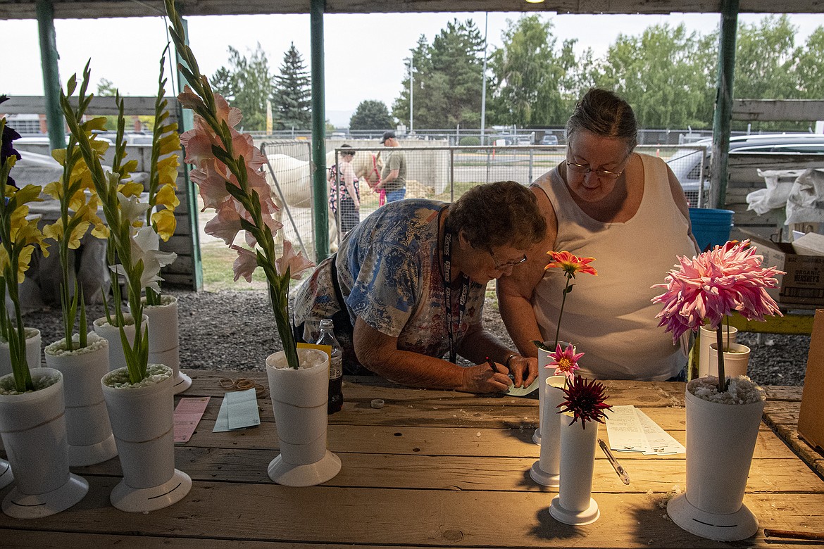 Dahlia show Superintendent Sharon Askelson and Kathy David write down entry information before the show at Flathead County Fairgrounds on Friday, Aug. 18. (Avery Howe/Hungry Horse News)