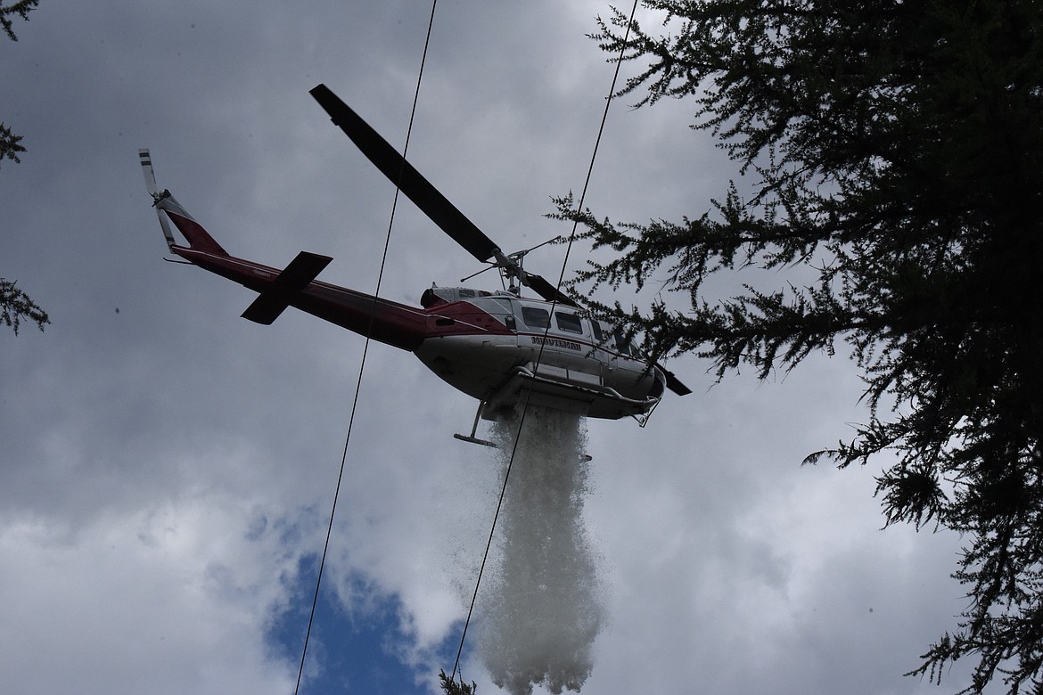 A Minuteman helicopter dumps water on the Powerline Fire Friday afternoon on Bobtail Road north of Libby. (Scott Shindledecker/The Western News)