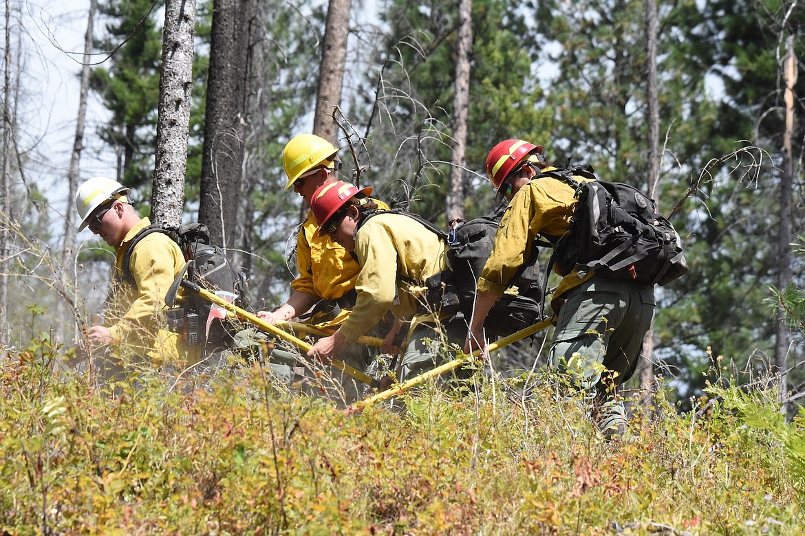 Kootenai National Forest hand crews dig a line around the Powerline Fire on Bobtail Road north of Libby Friday afternoon. (Scott Shindledecker/The Western News)