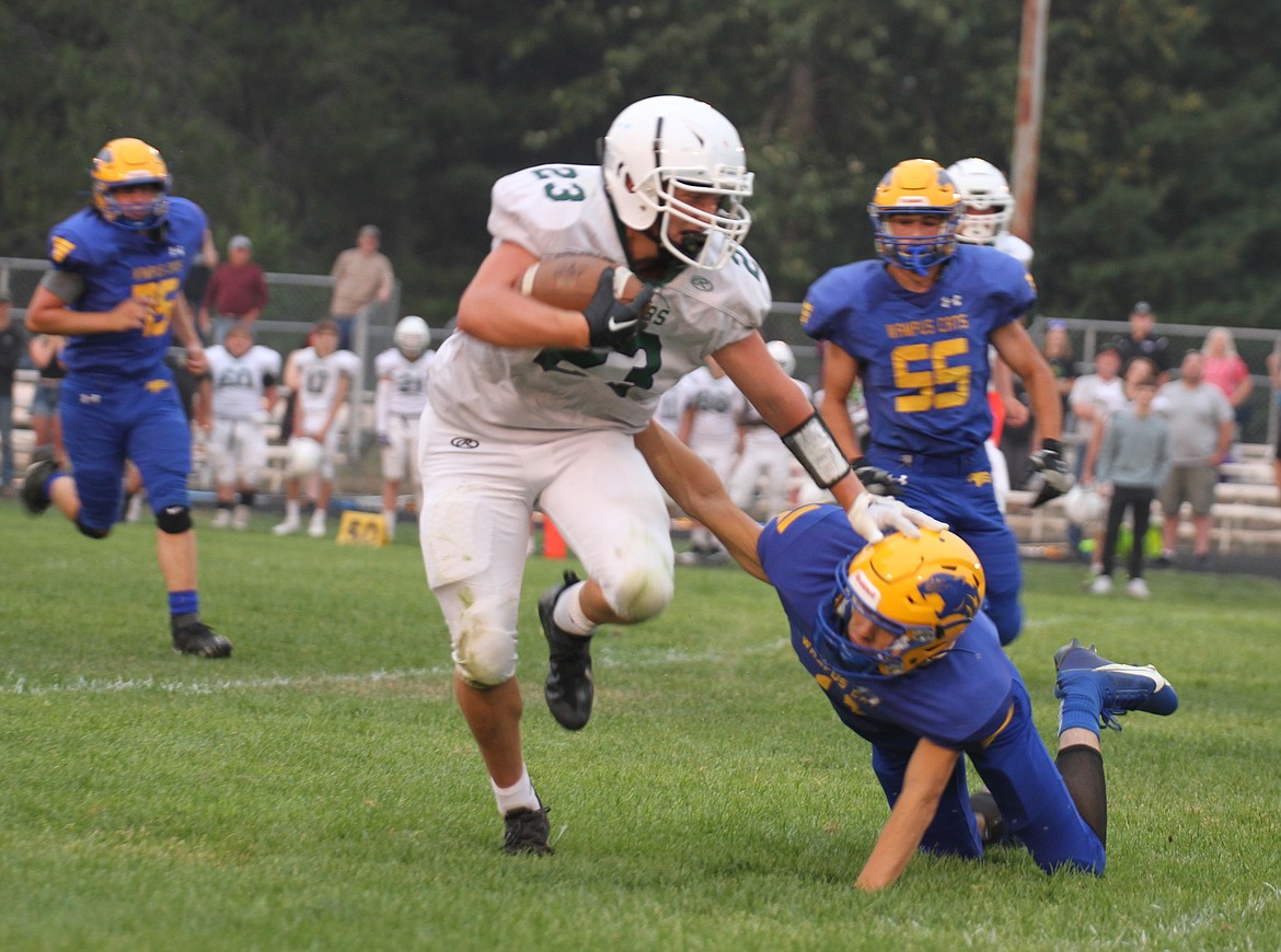 John Pruitt of Mullan/St. Regis stiff arms a Clark Fork defender. Pruitt scored all three Mullan/St. Regis touchdowns on Friday.