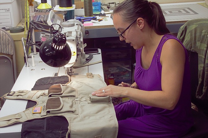 A Cowell Tactical employee works to refurbish an exterior carrier vest.
