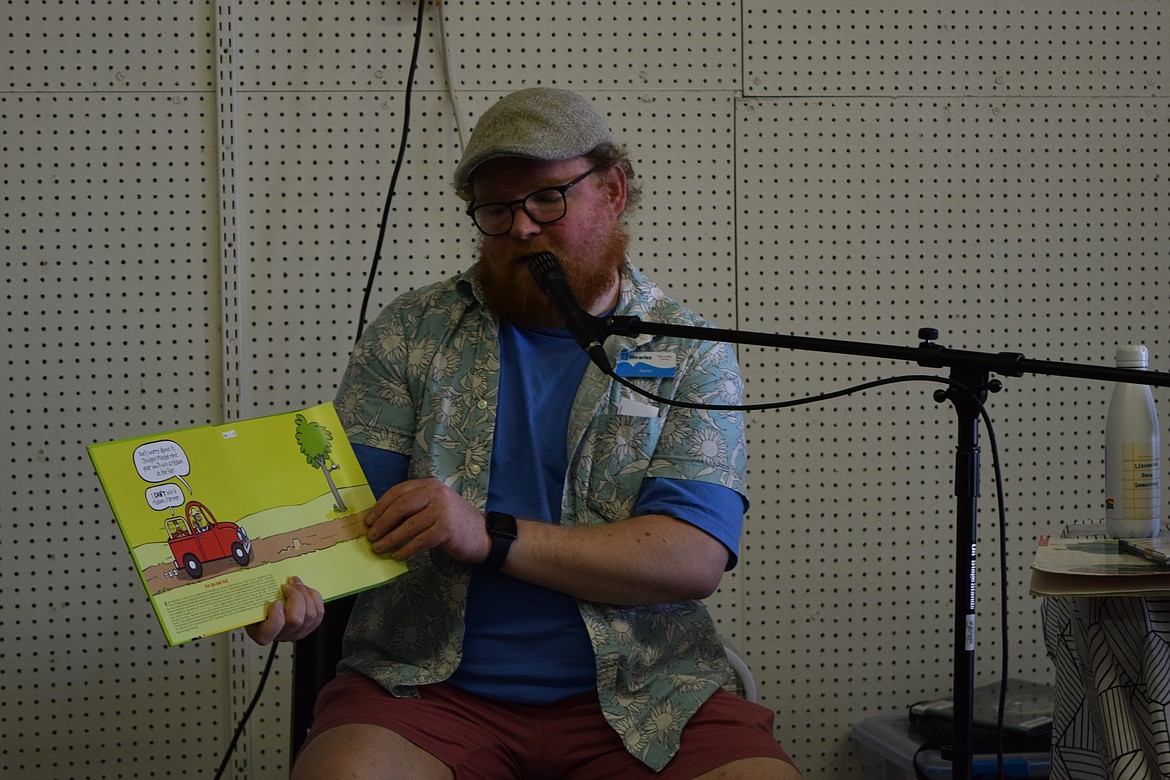 Aaron Loeffelbein, the branch supervisor of the Ephrata Public Library, reads The Chicken Who Couldn’t to children during the Friday 11:30 a.m. storytime in the Youth Building of the Grant County Fair.