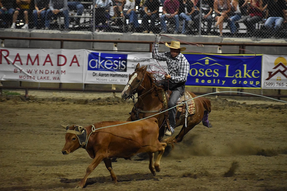 Team ropers rush toward a steer during Friday night’s Moses Lake Roundup Rodeo at the Grant County Fairgrounds.