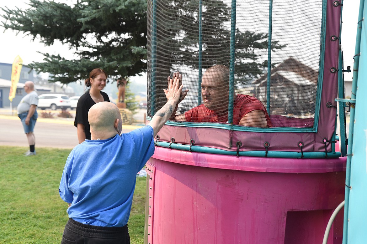 Achievements staff member Tory Sagen congratulates Shon at the dunking booth at the 2023 Ignite the Nites Car Show. (Scott Shindledecker/The Western News)