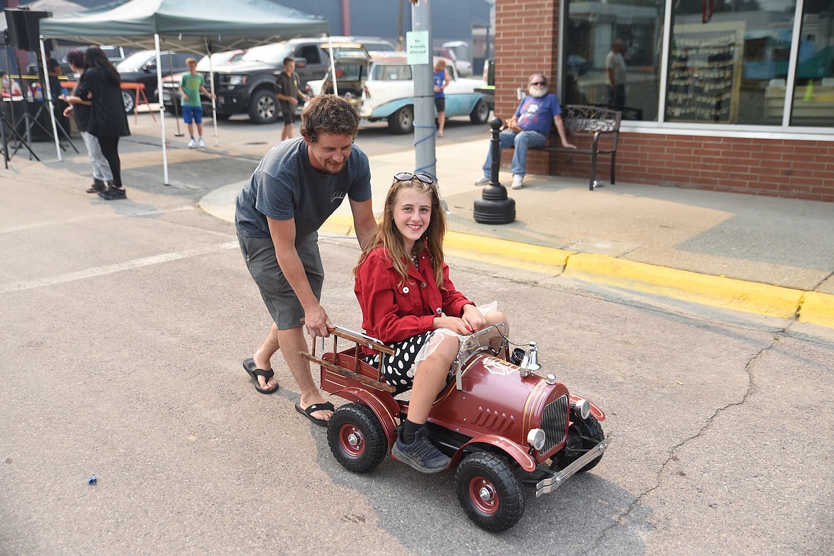 McMinnville, Oregon's Jersey Thompson takes a ride in the pedal car after winning the raffle at the 2023 Ignite the Nites Car Show. Marc Arsenault, of Creston, British Columbia, built it. (Scott Shindledecker/The Western News)