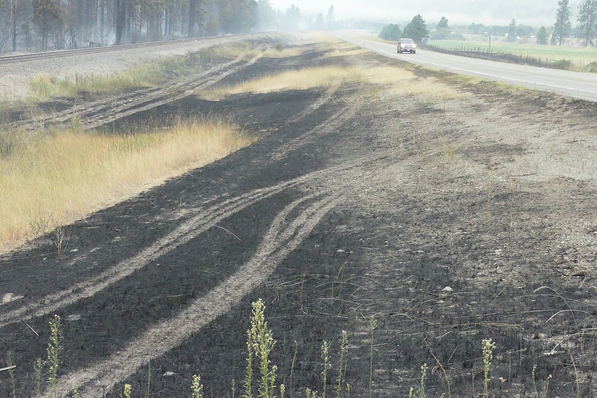 Tracks from a firefighting truck mark the remnants of a fire that broke out along Montana 200 south of Paradise on Friday. (Chuck Bandel/VP-MI)