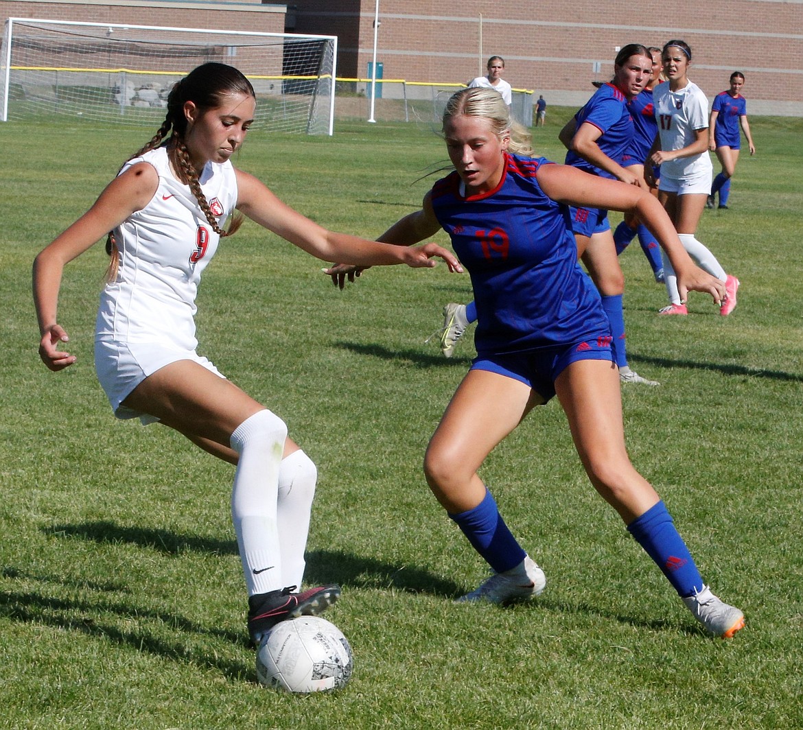 Sandpoint sophomore defender Ava Glahe dribbles past the defense of Coeur d'Alene junior defender Kaylie Smart during the first half of a scrimmage at Lake City High last week.