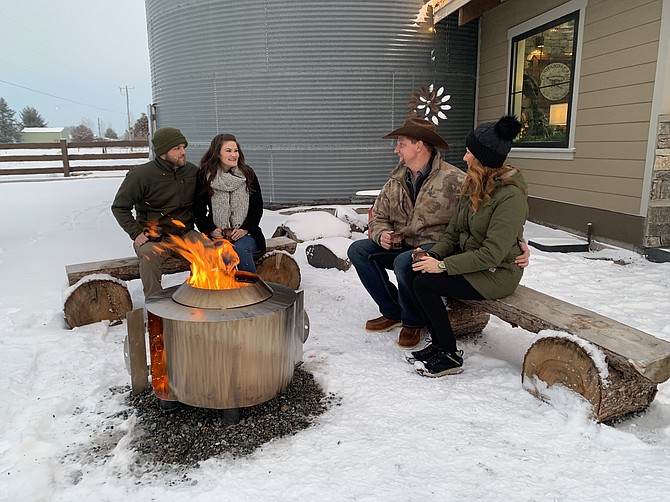 Cody and Rayna Wells bask in the warmth of the Revolve smokeless fire pit, alongside Krista Panerio and Justin Moody.
