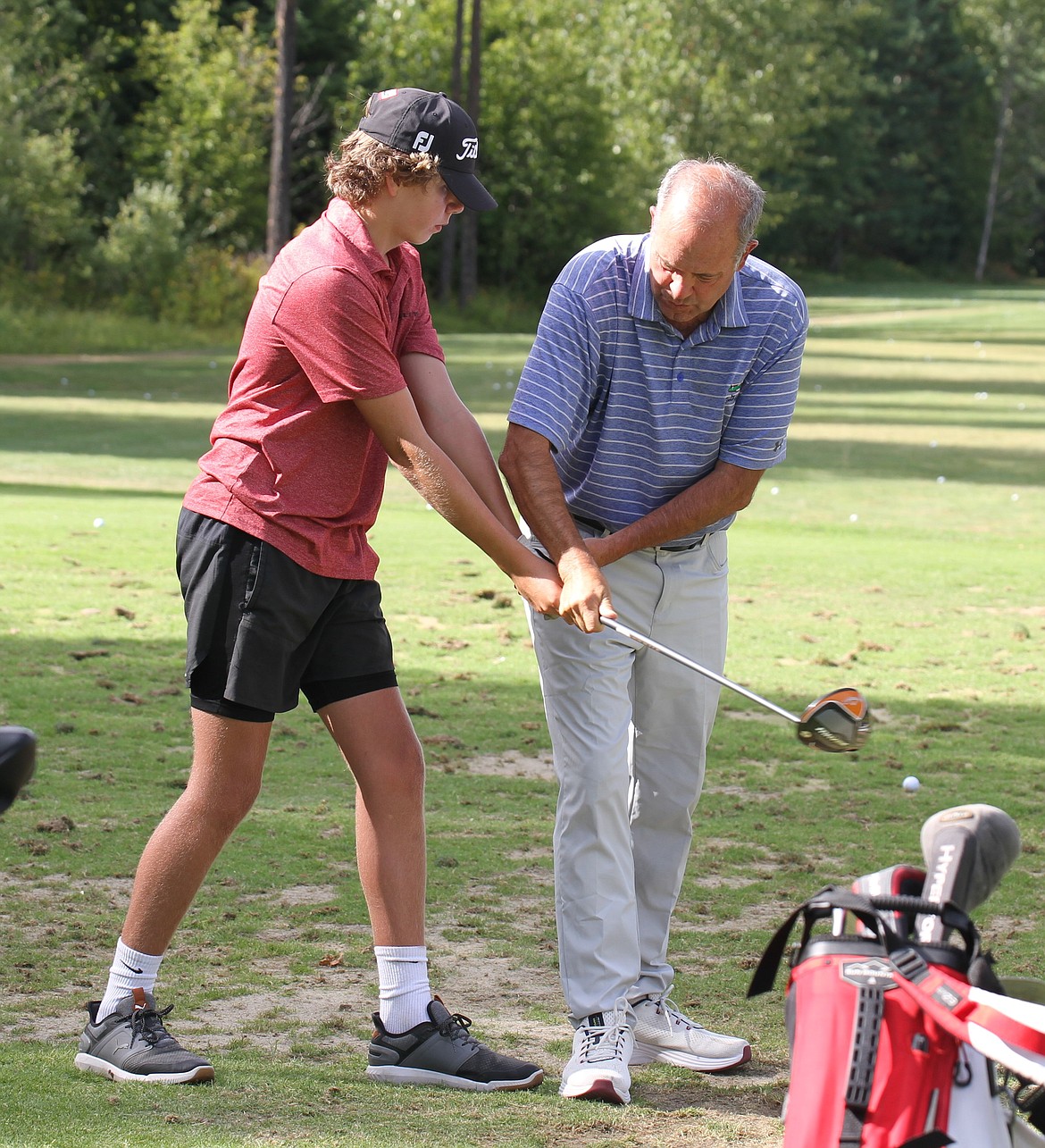 Sandpoint head coach Mike Deprez helps an athlete with their swing during a preseason practice at The Idaho Club.