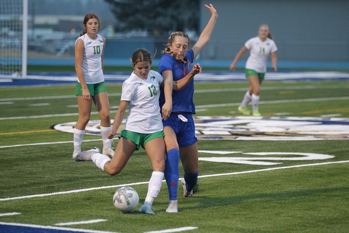 MARK NELKE/Press
Brook Gregory (12) of Lakeland and Gianna Callari of Coeur d'Alene vie for the ball Tuesday night in the first varsity soccer game on the new artificial turf field at Coeur d'Alene High.