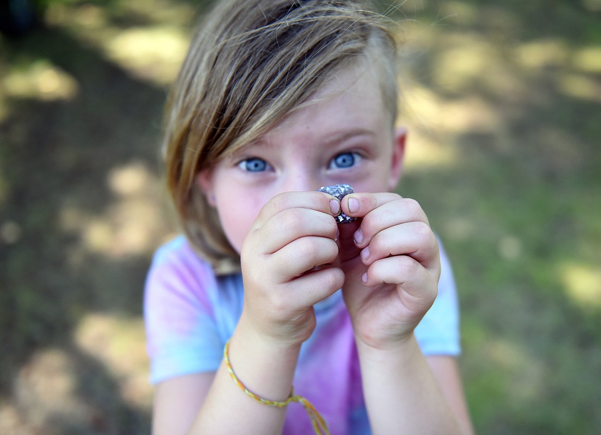 Camper Sage Vaughan with a piece of a glittery glue toy while at the park last week during the Whitefish Summer Camp program. (Julie Engler/Whitefish Pilot)