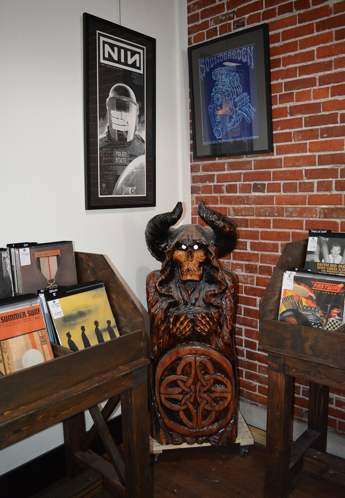 A wooden sculpture evoking the Tin Snug's logo is posted in a corner of the record store portion of the the business.