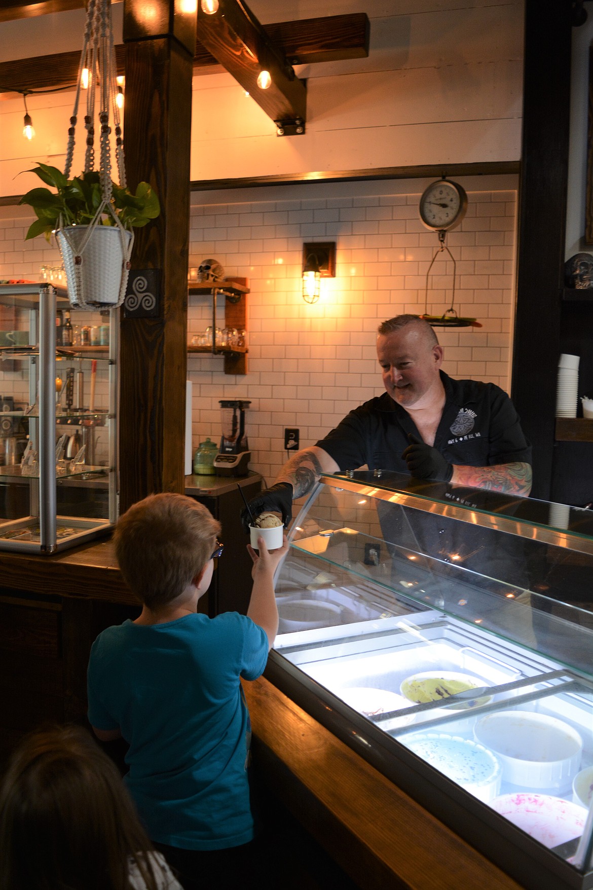 Brian Cleveland hands out ice cream to Lucas Stover, 9, at the Tin Snug. The Irish-style café/vinyl store combines all of the passions the business owners have in one place.