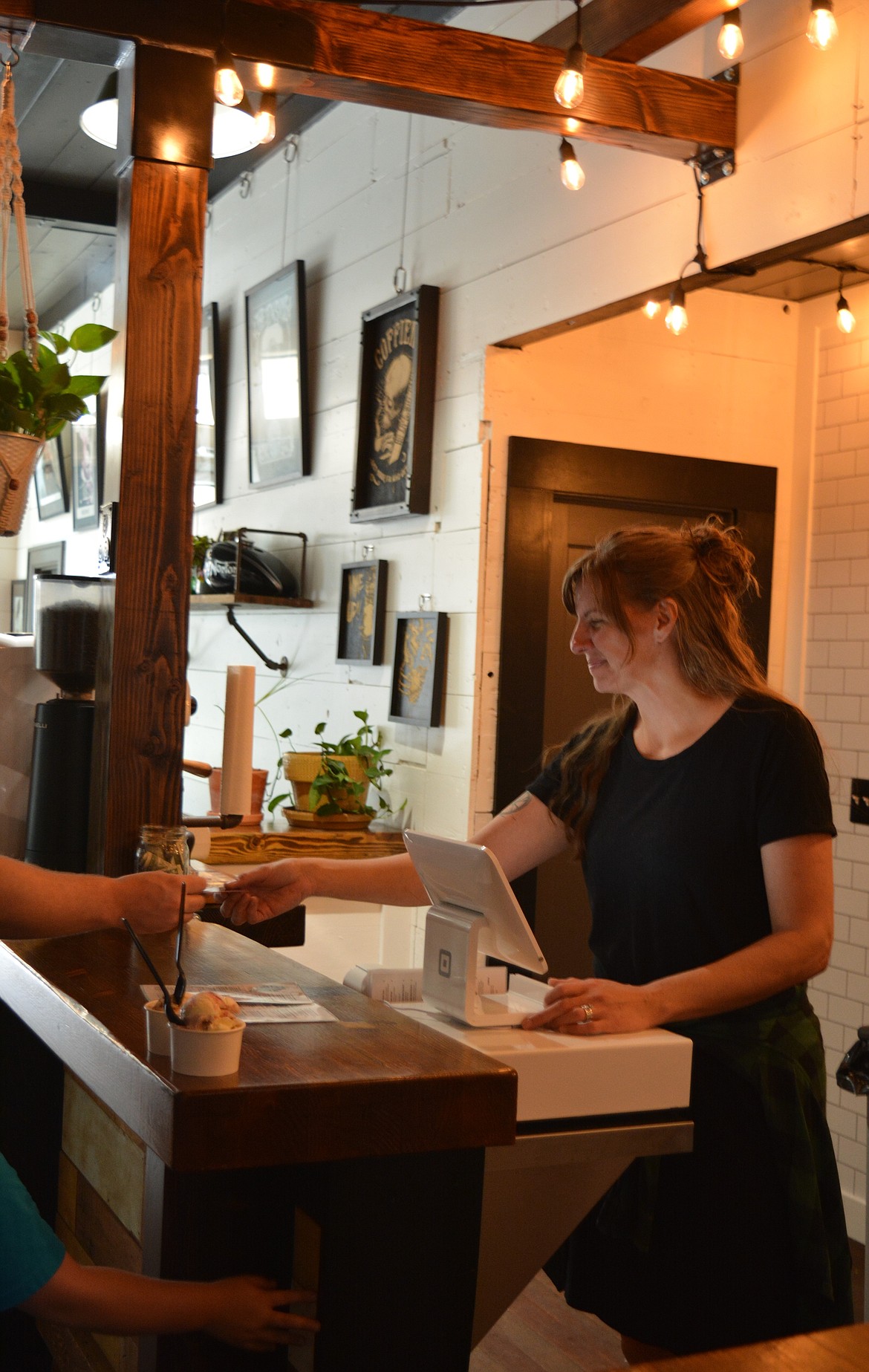 Karie Cleveland rings up a food order at the counter of the Tin Snug. The Clevelands opened their combined café and record store in Wallace in early August after relocating from the Portland/Vancouver area.