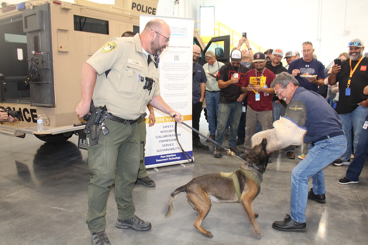 Moses Lake Industries president Hiroyuki Era, right, volunteered to be the demonstration partner for K-9 Edo and his handler Tyson Voss, left, during a ceremony recognizing a donation from MLI for a new GCSO K-9.