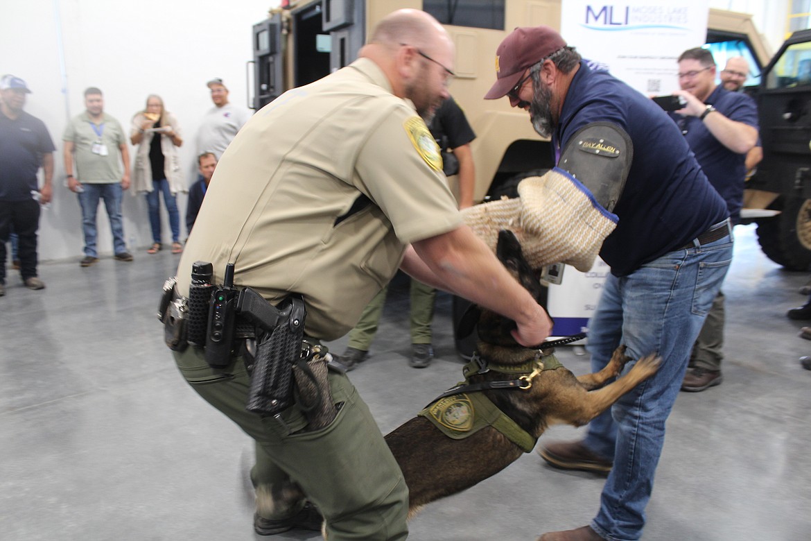 Moses Lake Industries employee David Rowland, right, volunteered to be a demonstration subject for K-9 Edo and his handler Tyson Voss, left.