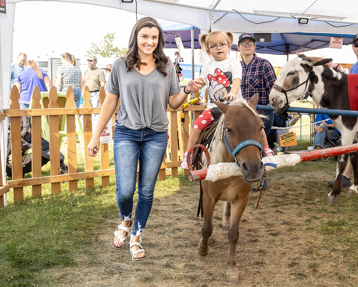 Caitlyn Schmidt and daughter Aspen enjoy a pony ride Wednesday at the fair.